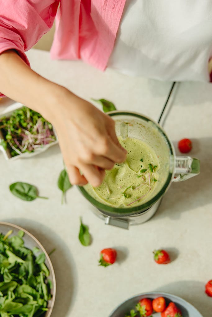 Vegetables next to a blender for juicing.